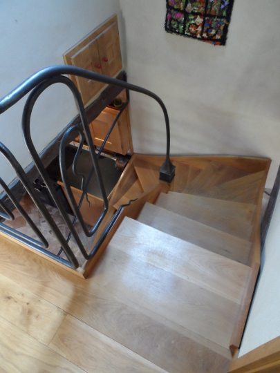 Escalier ouvert en bois avec une balustrade en acier forgé 